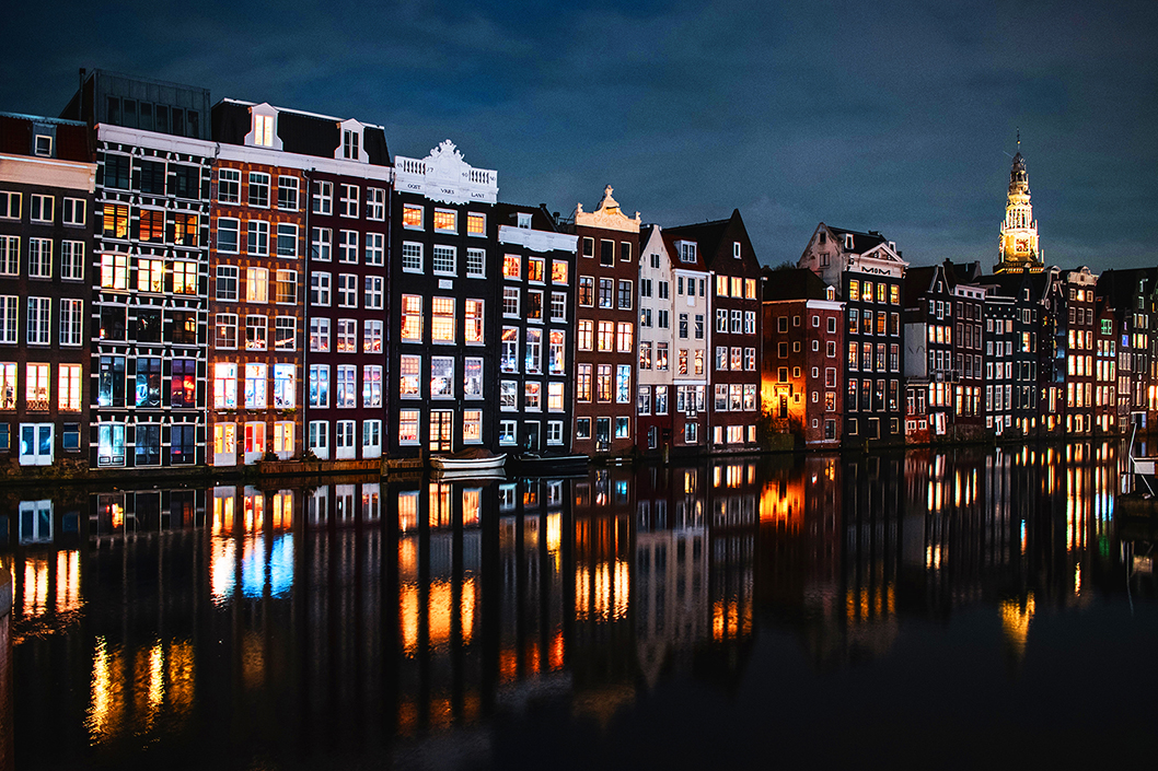 Een verlichte straat met grachtenpanden in Amsterdam